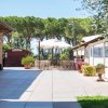 Cortile con tavoli, ombrelloni e vegetazione.