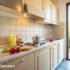 Cucina con piano in marmo, pomodori, e luce naturale.