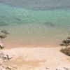 Spiaggia tranquilla con acqua cristallina e rocce.