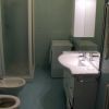 Bagno moderno con doccia, bidet, lavandino doppio e lavatrice. Pareti con piastrelle verdi.