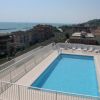 Piscina sul tetto con vista sul mare e palazzi circostanti.
