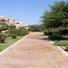 Viale con giardini e edifici in pietra.