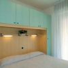 Camera da letto con armadio verde e tende bianche.