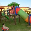 Bambini giocano su una struttura colorata in un parco giochi.