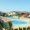 Complesso con piscine, ombrelloni e edifici residenziali.
