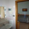 Bagno con specchio, asciugacapelli e vista su camera da letto con letto matrimoniale.