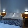 Letto matrimoniale con testiera in legno e luci soffuse.