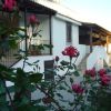 Una casa bianca con rose rosse in primo piano.