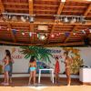 Persone sotto gazebo con decorazioni colorate, conversano vicino a un tavolo.