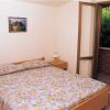 Camera da letto con letto matrimoniale e porta aperta su un balcone.