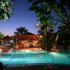 Piscina illuminata di notte con decorazioni e piante.