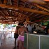 Due persone al bancone di un bar all'aperto con tetto in legno.