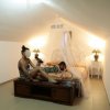 Due persone in una stanza con letto e zanzariera.