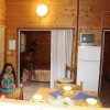 Interno in legno con due persone e un frigorifero.