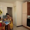 Due persone a tavola in cucina, leggono una rivista.
