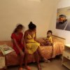 Tre persone sedute su un letto, rivista accanto.