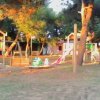 Parco giochi con scivoli e alberi.