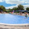 Piscina con sdraio e ombrelloni blu.