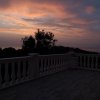 Tramonto visto da un balcone con balaustra.