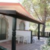 Portico con tavolo e sedie bianche vicino a una casa.