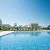 Piscina con piastrelle blu e ombrelloni bianchi.