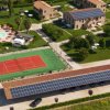 Vista aerea di complesso con piscina e campo da tennis.