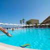 Tuffo in piscina con ombrelloni bianchi.
