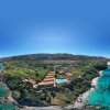 Vista aerea di un resort sul mare con piscine.