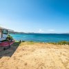 Camper parcheggiato vicino a una spiaggia con vista sull'oceano.