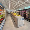 Interno di un negozio di alimentari con frutta e verdura esposta.