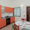Cucina con mobili arancioni e tavolo apparecchiato.