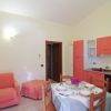 Soggiorno con cucina arancione e divano.