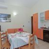 Cucina con mobili arancioni e tavolo apparecchiato.