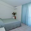 Camera da letto con letto matrimoniale e tende azzurre.