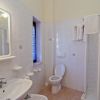 Bagno con doccia, lavabo, specchio e wc.