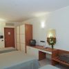 Camera d'albergo con letti singoli e TV.