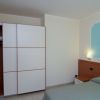 Camera con letto e ampio armadio bianco.