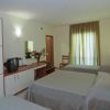 Camera d'hotel con tre letti e TV.