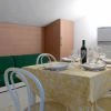 Tavolo apparecchiato in una sala da pranzo con sedie bianche.