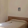 Camera con due letti singoli, libro sul letto e finestra con vista alberi.