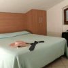 Una camera con letto matrimoniale e valigia.