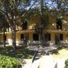 Un edificio giallo a due piani circondato da alberi, con una scala a chiocciola al centro.
