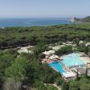 Vista aerea di un complesso con piscina e mare.
