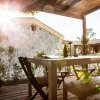 Tavolo all'aperto sotto pergola con sole splendente.