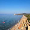 Spiaggia con ombrelloni e mare calmo.