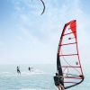 Windsurf e kitesurf in mare con cielo sereno.