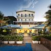 Facciata dell'hotel con terrazza e ombrelloni.