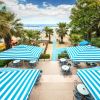 Tavoli con ombrelloni a strisce blu e bianche vicino al mare.