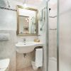 Bagno moderno con doccia e specchio dorato.
