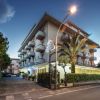 Facciata di un hotel con balconi e palme.